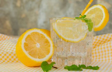 Tatlı yaz limonatası, meyve suyu ve nane aromalı taze limon kokteyli güzel sarı şebeke masa örtüsü..