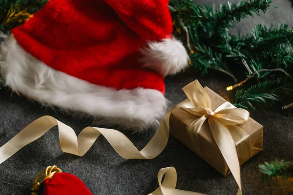 Noel Baba şapkası ve gri arka planda Noel ışıklarıyla Noel süslemeleri..
