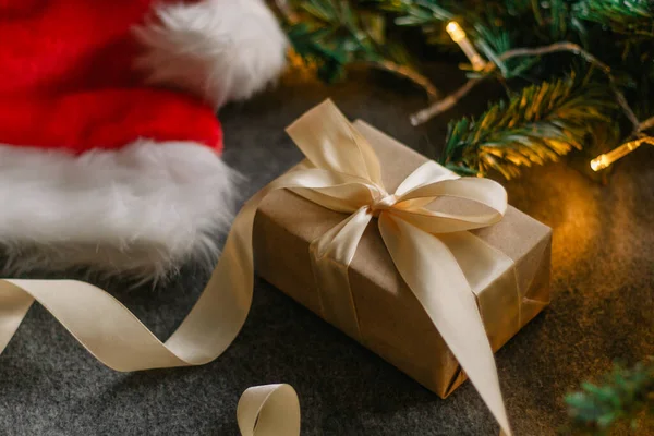Noel Baba şapkası ve gri arka planda Noel ışıklarıyla Noel süslemeleri..