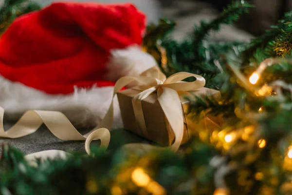 Noel Baba şapkası ve gri arka planda Noel ışıklarıyla Noel süslemeleri..