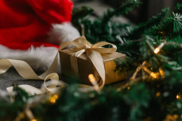 Noel Baba şapkası ve gri arka planda Noel ışıklarıyla Noel süslemeleri..