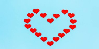 Kalp şeklinde çerçeve konfeti ve mavi arka planda fiyonklardan yapılmış. Sevgililer Günü 'nün geçmişi. Düz görünüm, üst görünüm, kopyalama alanı. Pankart.