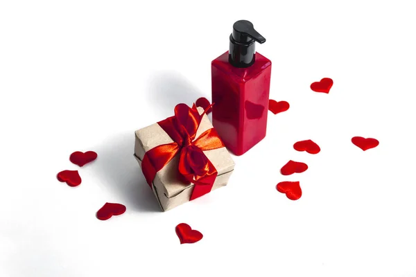 Una Bottiglia Rossa Lozione Accanto Una Confezione Regalo Legata Con — Foto Stock