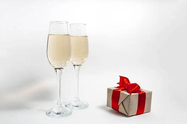 Zwei Gläser Champagner Und Eine Geschenkbox Mit Roter Schleife Auf — Stockfoto