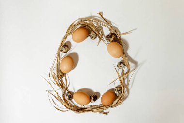 Paskalya yumurtası şekli yumurta ve samandan yapılmıştır. Minimum tatil konsepti. Düz ley, üst görünüm. .