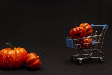 Arabadaki turuncu balkabakları ve siyah arka planda dağınık balkabakları. Cadılar Bayramı 'nda satıştan bahseden yassı lei. Boşluğu kopyala.