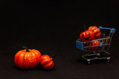 Arabadaki turuncu balkabakları ve siyah arka planda dağınık balkabakları. Cadılar Bayramı 'nda satıştan bahseden yassı lei. Boşluğu kopyala.