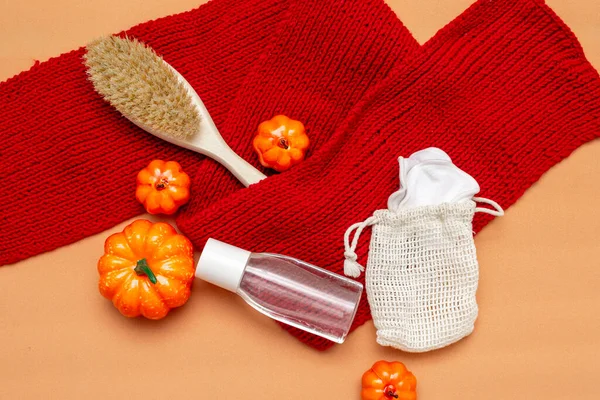 化妆洗涤剂 刷子和天然可重复使用的海绵在一个米色背景的袋子与红色围巾和橙色南瓜 秋天的布局 — 图库照片