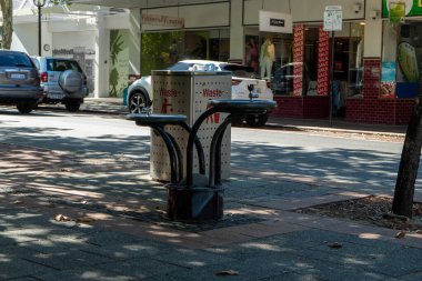 Avrupa tarzı şık kıyafetler giymiş erkek manken. Yanında bir çanta, dizüstü bilgisayar ve anahtarla bir bank ve kafede.