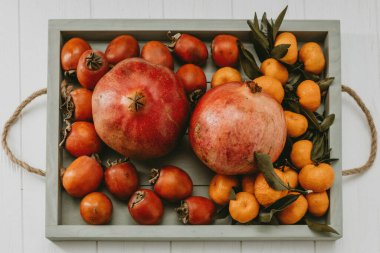 Hafif arkaplanlı nar, mandalina ve hurma tepsileri 