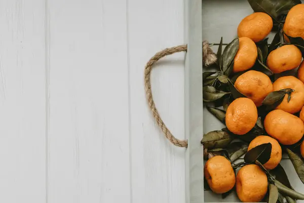 Hafif bir zemin üzerinde yeni yıl mandalinaları olan tepsi 