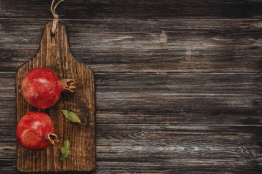 Tahtanın tepesinde iki kırmızı nar. 