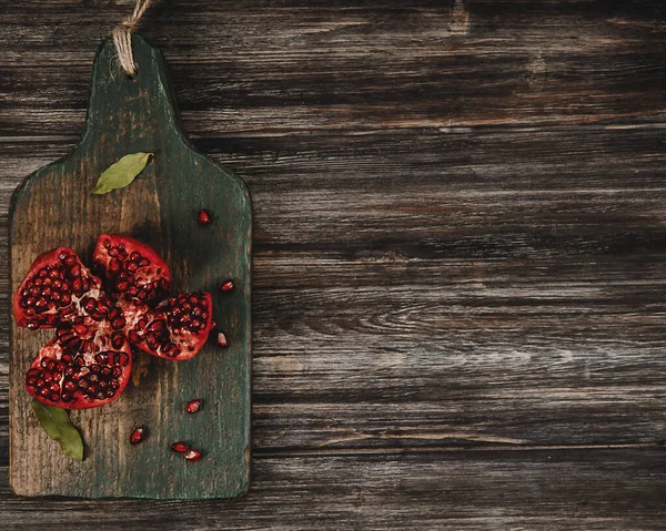 Ahşap bir arka planda rustik tarzda kırmızı nar. 