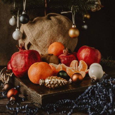 Yılbaşı sofrası için koyu bir arka planda meyveler.