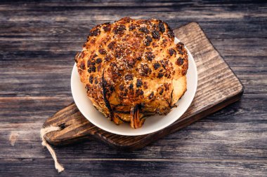 Tahta bir masada, parşömende ateşte pişmiş karnabahar. 