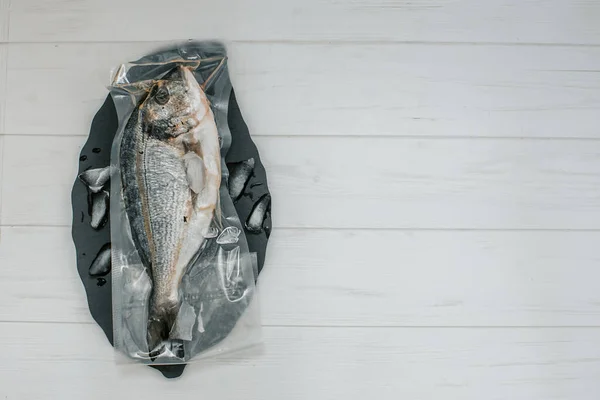 Metnin altında bir yeri olan vakum ambalajında taze balık 