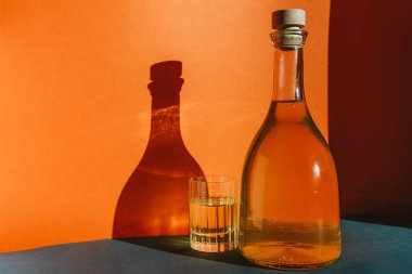 Renkli bir arka planda batan güneşin ışınlarında turuncu limonata.