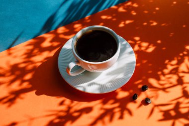 Bir fincan sade kahveyle siyah bir arka planda kahvaltı. 