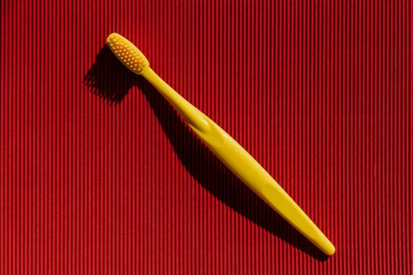 Dişleri renkli bir arkaplanda fırçalamak için diş fırçası ve metin altında bir yer