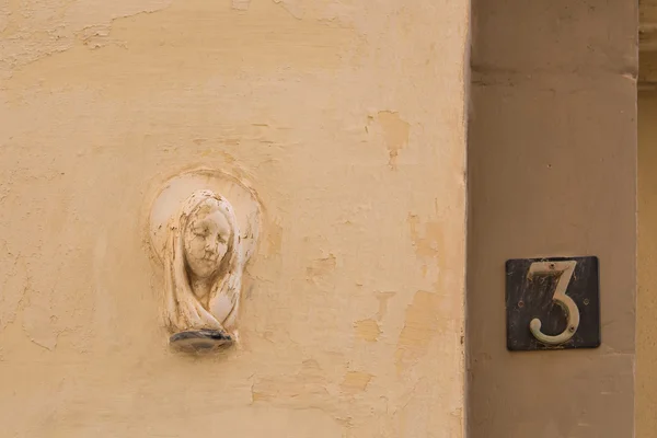 Santo retrato - escultura en la pared de una casa — Foto de Stock