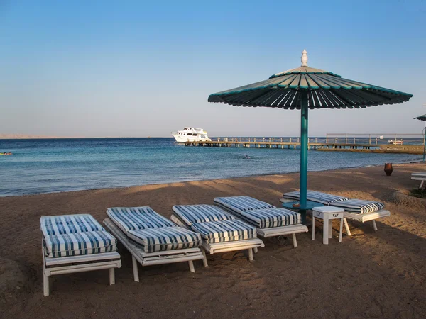 Dört sandalye ve şemsiye ile plaj — Stok fotoğraf