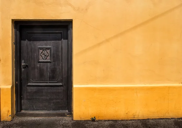 Puerta oscura en una pared naranja — Foto de Stock