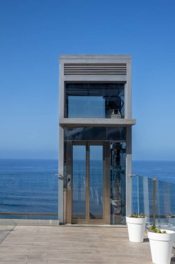 Uçurumun kenarındaki bir terasta asansör. Atlantik Okyanusu manzarası. Parlak mavi gökyüzü. Puerto Cruz, Tenerife, Kanarya Adaları, İspanya.