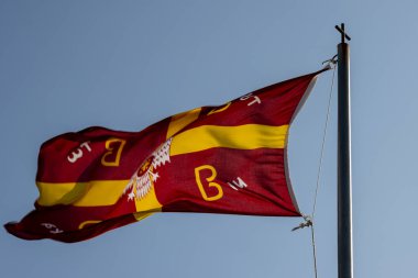 Bizans bayrağının direkte sallanmasının tarihi geleneği. Arka planda mavi gökyüzü. Korfu (Korfu), Yunanistan.