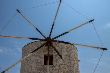 Taştan yapılmış bir yel değirmeninin ayrıntıları. Arka planda açık beyaz bulutlar olan mavi gökyüzü. Anemomilos, Kerkyra, Korfu (Korfu), Yunanistan.