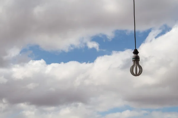 Light bulb and a cloudy sky — Stock Photo, Image