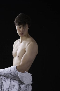 Düşünceli genç adam gömleğini çıkarmış.