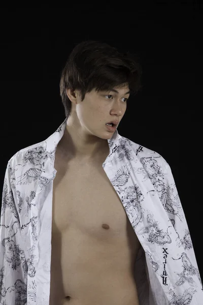 Yakışıklı genç adam göğsünü gösteriyor.