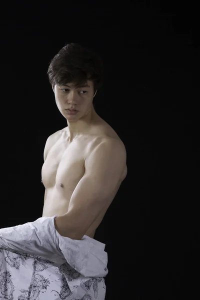 Düşünceli genç adam gömleğini çıkarmış.