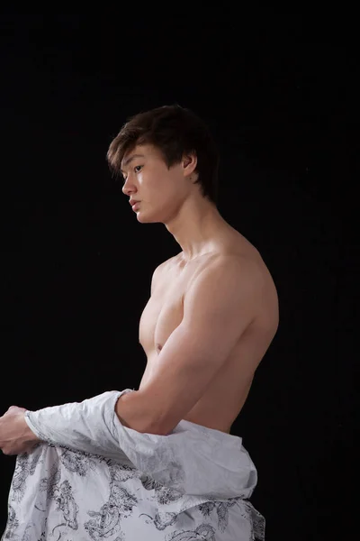 Düşünceli genç adam gömleğini çıkarmış.