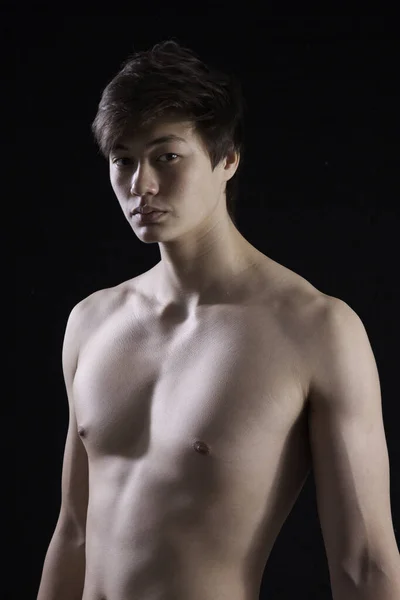 Düşünceli genç adam gömleğini çıkarmış.