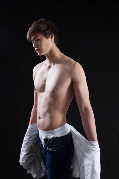 Düşünceli genç adam gömleğini çıkarmış.