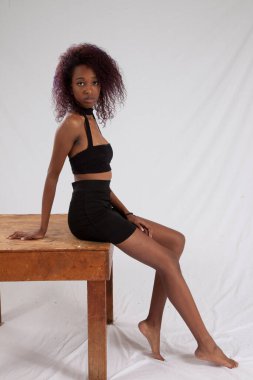 Düşünceli siyah kadın oturuyor.