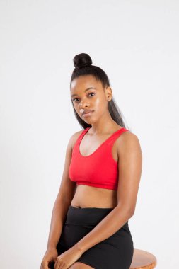 Düşünceli siyah kadın bir taburede dinleniyor.