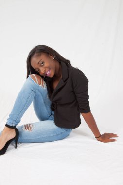 Gülümseyerek yerde oturan mutlu siyah kadın