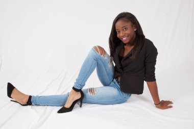 Gülümseyerek yerde oturan mutlu siyah kadın