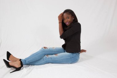 Gülümseyerek yerde oturan mutlu siyah kadın