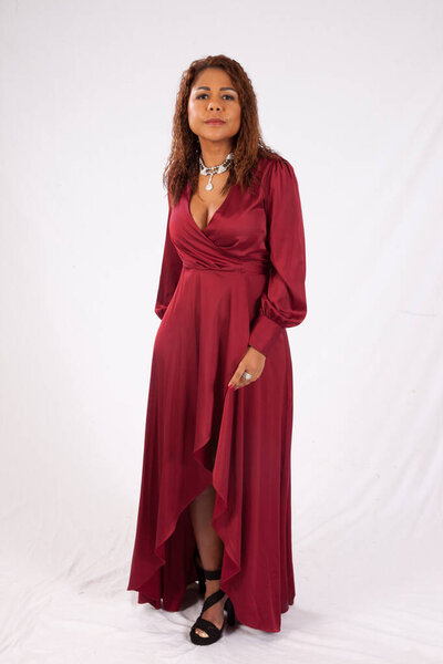 Милая латиноамериканка, задумчиво выглядящая в красном платье.