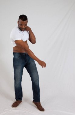 Yakışıklı siyah adam gömleğini kaldırıyor.