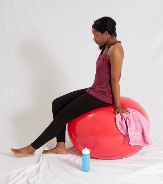 Mulher Negra Pensativo Sentado Uma Bola Exercício Vermelho — Fotografia de Stock