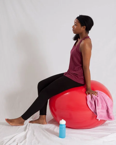 Mulher Negra Pensativo Sentado Uma Bola Exercício Vermelho — Fotografia de Stock