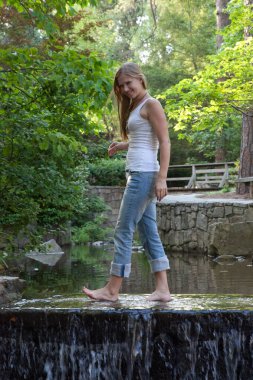 Mutlu sarışın bir baraj ve şelalede uyanıyor.