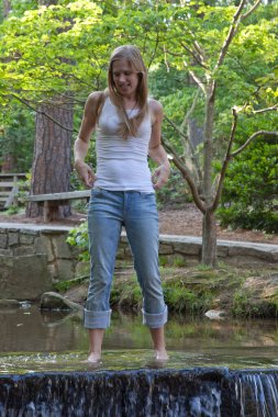 Mutlu sarışın bir baraj ve şelalede uyanıyor.