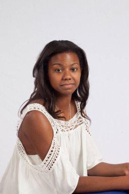 Düşünceli siyah kadın oturuyor.