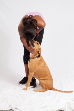 Güzel siyah kadın evcil köpeğiyle oynuyor..