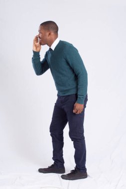 Yakışıklı siyah adam eli ağzının kenarında konuşuyor..